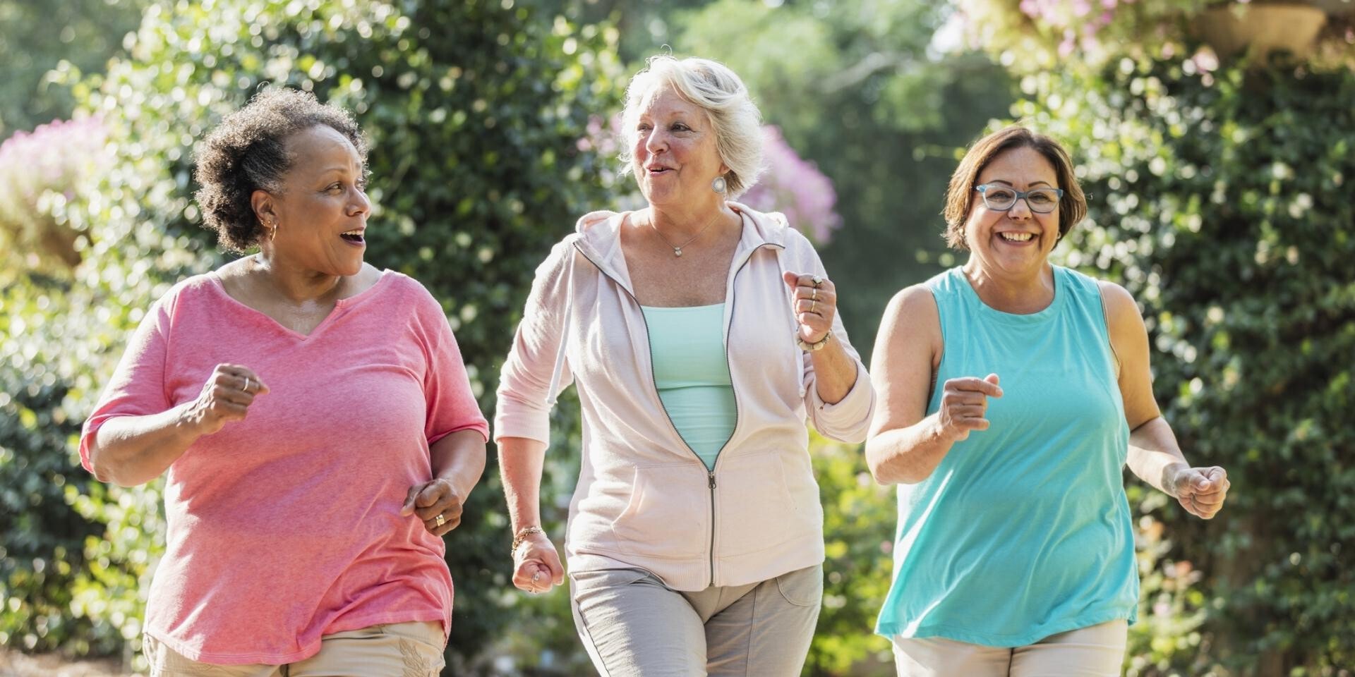 Drie vrouwen hardlopen in de natuur.